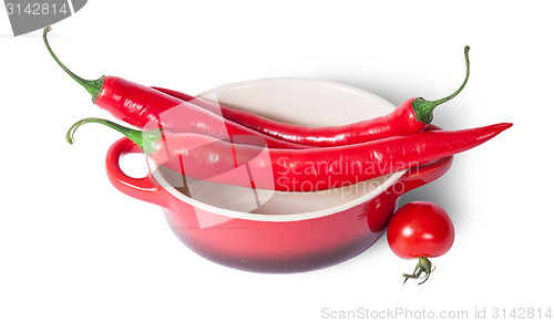 Image of Chili peppers on the saucepan and cherry tomatoes near