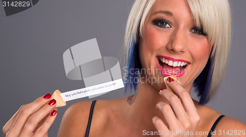 Image of Pretty Blonde Woman Eats Fortune Cookie Showing Message