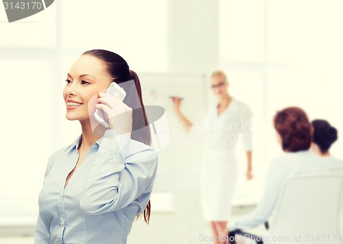 Image of young smiling businesswoman with smartphone