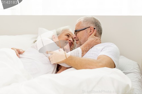 Image of happy senior coupler lying in bad at home