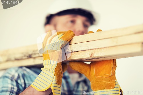 Image of close up of male in gloves carrying wooden boards