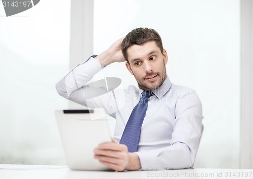 Image of stressed businessman with tablet pc and documents