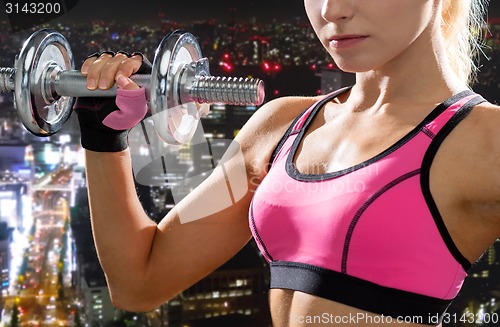 Image of close up of sporty woman with heavy steel dumbbell