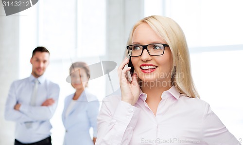 Image of smiling businesswoman calling on smartphone