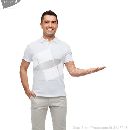 Image of smiling man showing something on empty palm