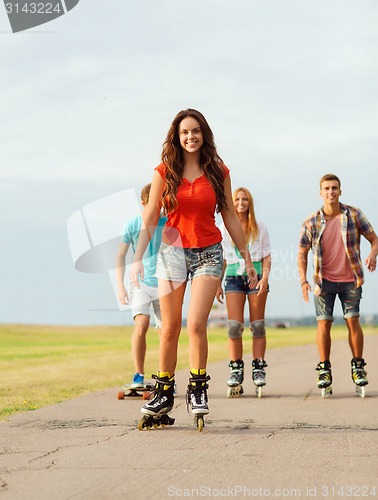 Image of group of smiling teenagers with roller-skates