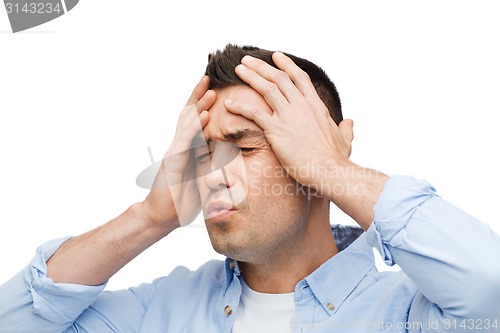 Image of unhappy man with closed eyes touching his forehead