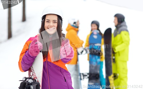 Image of happy friends in helmets with snowboards