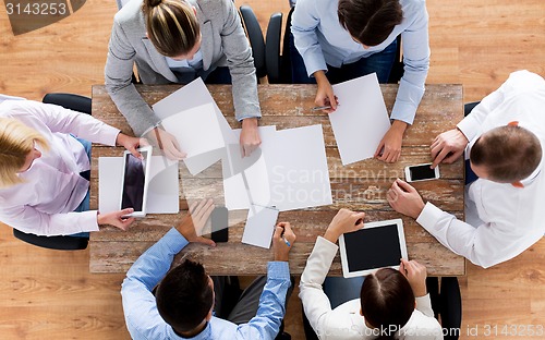 Image of close up of business team with papers and gadgets