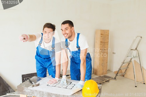 Image of group of builders with blueprint