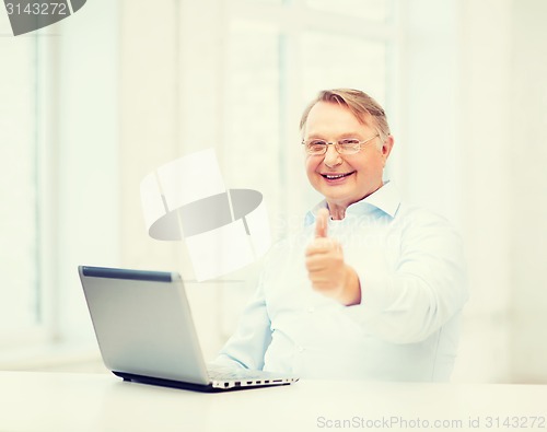 Image of old man with laptop computer showing thumbs up