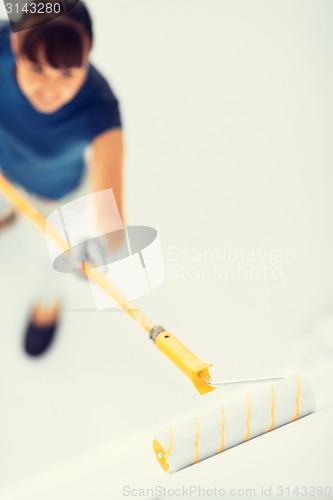 Image of woman with roller and paint colouring the wall