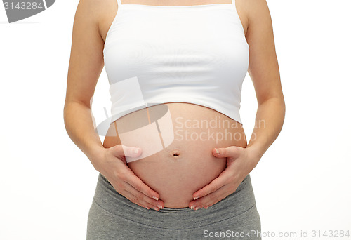 Image of close up of pregnant woman touching her bare tummy