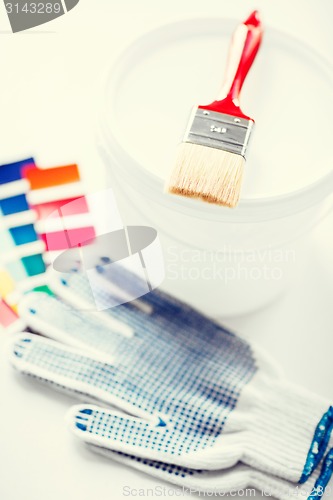 Image of paintbrush, paint pot, gloves and pantone samples