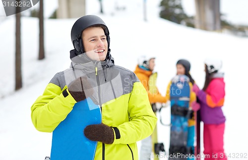 Image of happy friends in helmets with snowboards