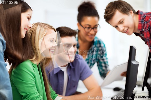 Image of students looking at computer monitor at school