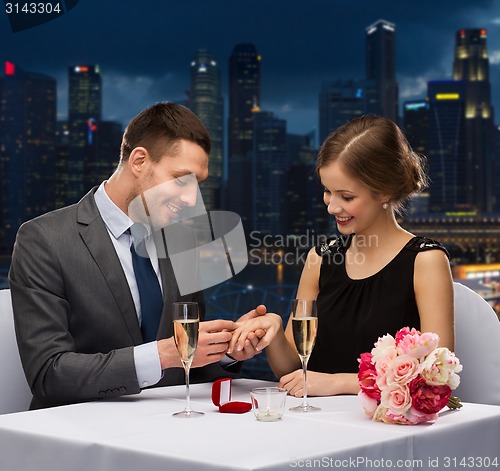 Image of smiling couple with wedding ring at restaurant
