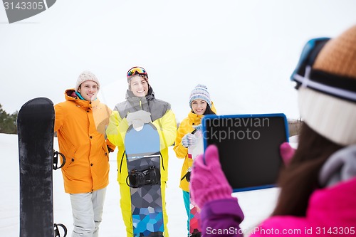 Image of happy friends with snowboards and tablet pc