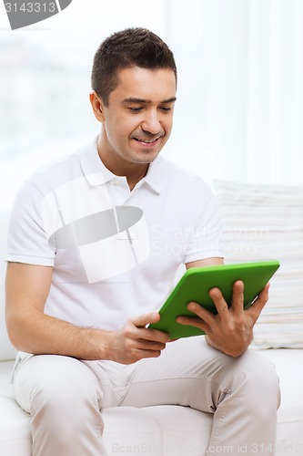 Image of smiling man working with tablet pc at home