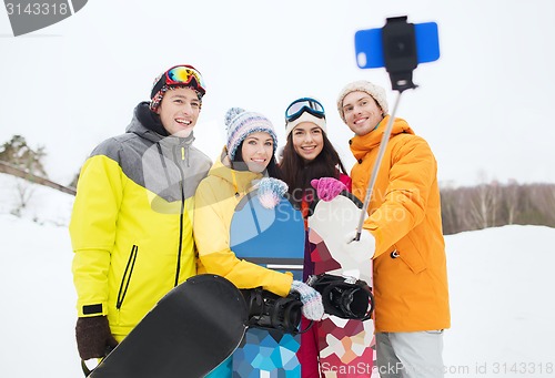 Image of happy friends with snowboards and smartphone