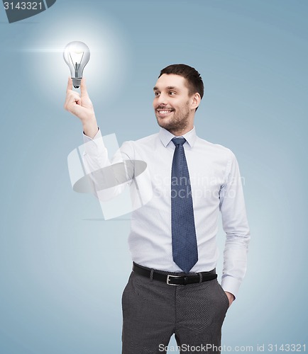 Image of handsome businessman holding light bulb