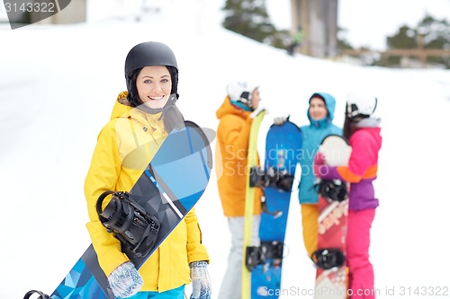 Image of happy friends in helmets with snowboards