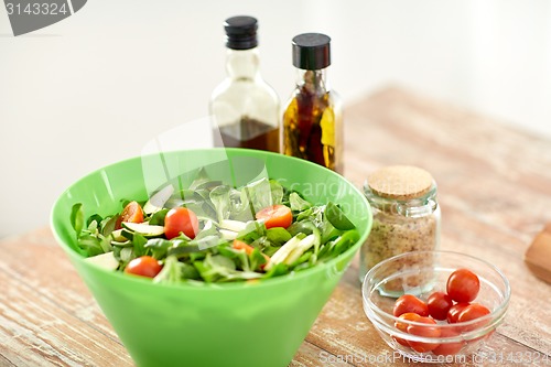 Image of close up of salad bowl and spices on kitchen table