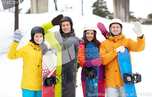 Image of happy friends in helmets with snowboards