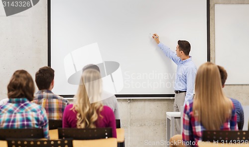 Image of group of students and smiling teacher in classroom