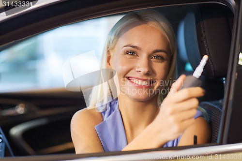 Image of happy woman getting car key in auto show or salon