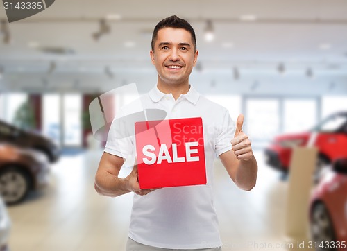 Image of smiling man with red sale sigh showing thumbs up