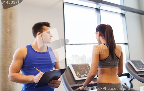 Image of woman with trainer on treadmill in gym