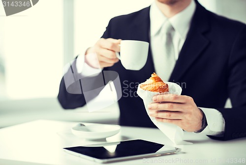 Image of man with tablet pc and cup of coffee