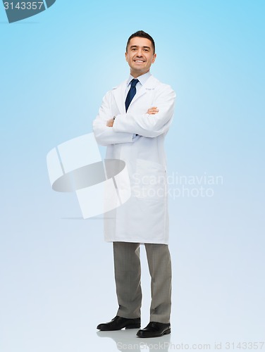 Image of smiling male doctor in white coat over blue
