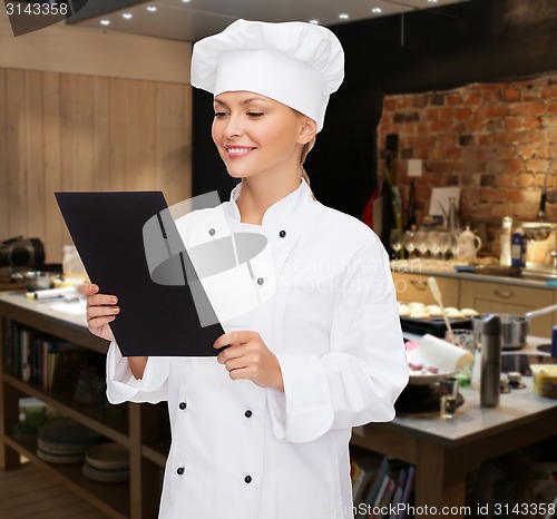 Image of smiling female chef with black blank paper