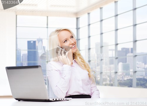 Image of smiling businesswoman calling on smartphone