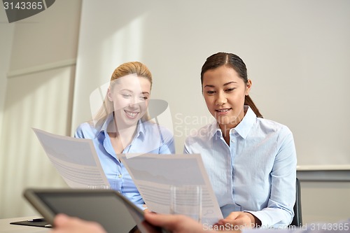 Image of smiling businesswomen meeting in office