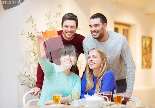 Image of group of friends taking selfie with smartphone