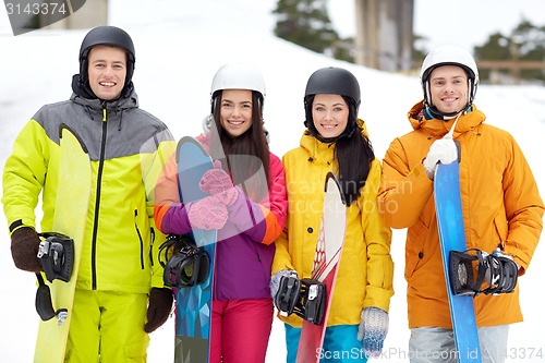 Image of happy friends in helmets with snowboards