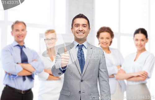 Image of happy businessman in suit showing thumbs up