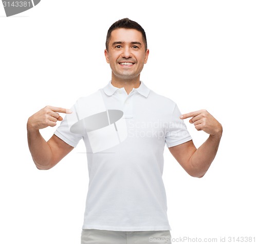 Image of smiling man in t-shirt pointing fingers on himself