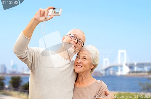 Image of senior couple with camera over rainbow bridge