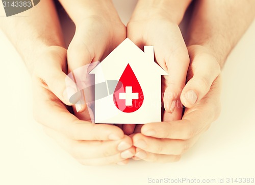 Image of hands holding house with donor sign