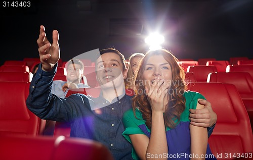 Image of happy friends watching movie in theater