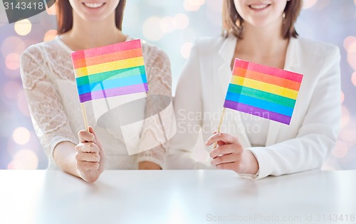 Image of close up of happy lesbian couple with rainbow flag