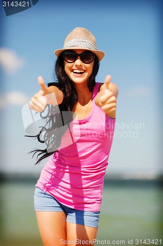 Image of girl showing thumbs up on the beach