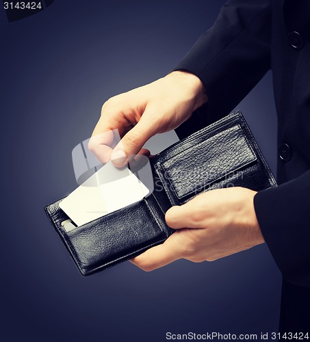 Image of man in suit holding credit card