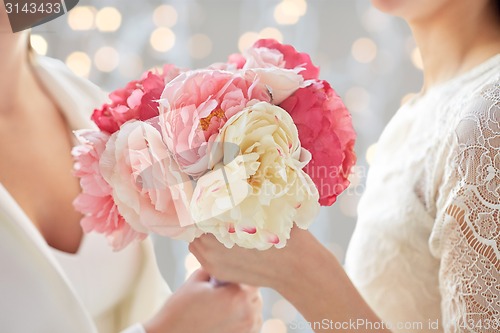 Image of close up of happy lesbian couple with flowers