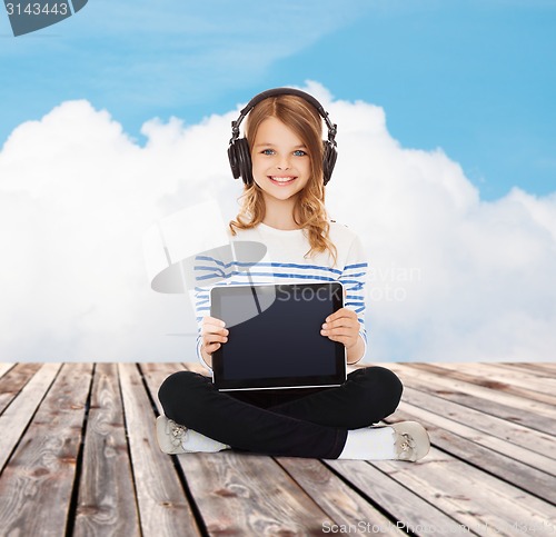 Image of happy girl with headphones showing tablet pc