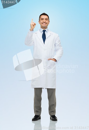 Image of smiling doctor in white coat pointing finger up